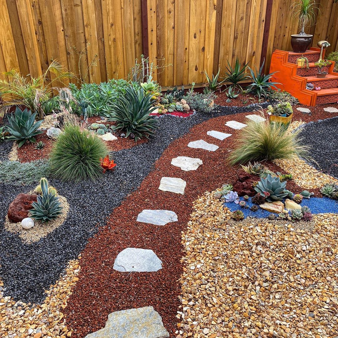 Multiple textures of mulch and rock placed in small yard.