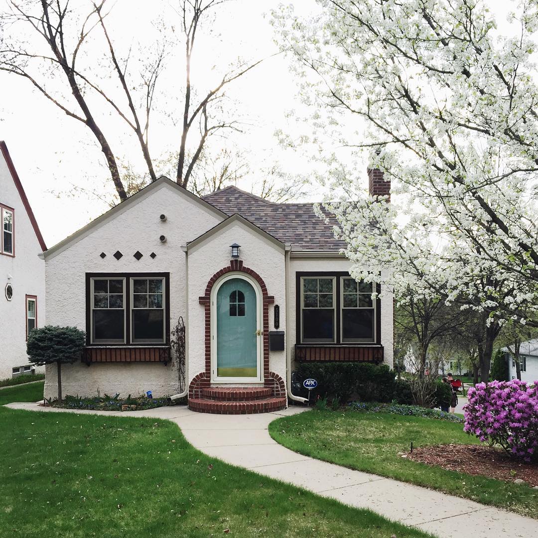 white bungalow home with teal door photo by Instagram user @imbreannarose