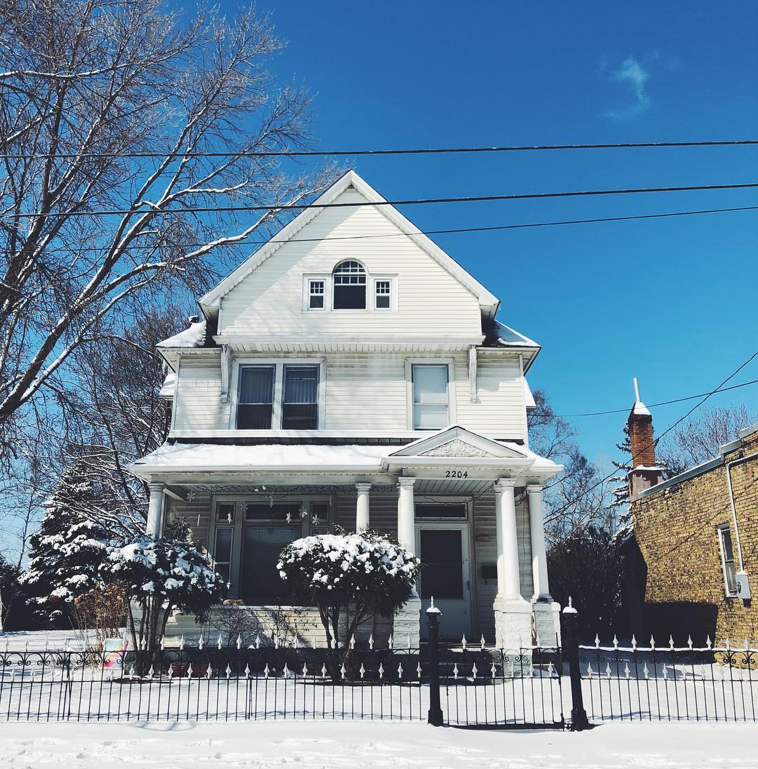 white craftsman style home in minneapolis with snow on the ground photo by Instagram user @northeastminneapolis