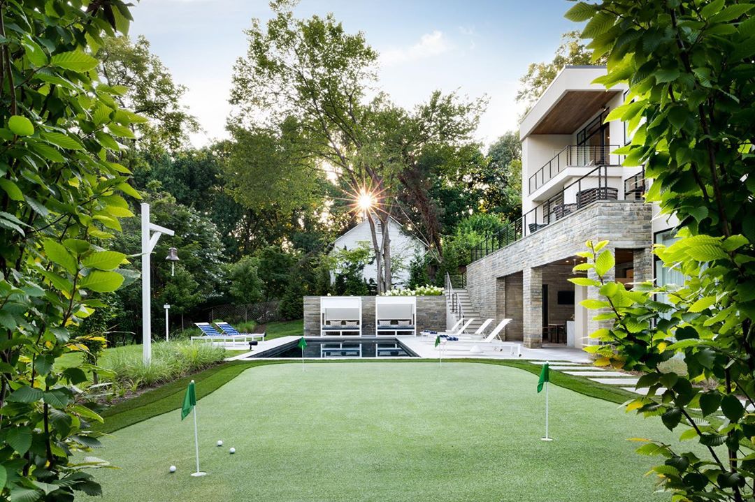 backyard putting green alongside pool in large backyard photo by Instagram user @jrichardsonla