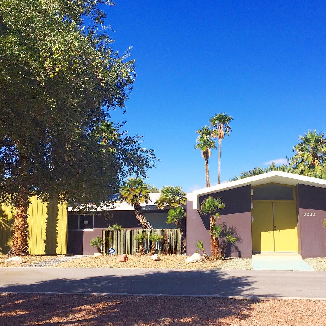 ranch style home with yellow doors and brown siding in Rancho Charleston, Las Vegas photo by Instagram user @eatdrinkhome