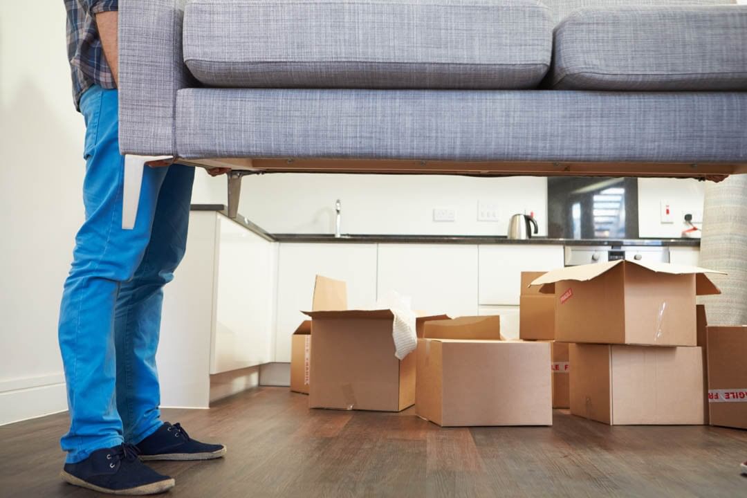 person moving a couch with moving boxes in the background photo by Instagram user @shepherdsmoving
