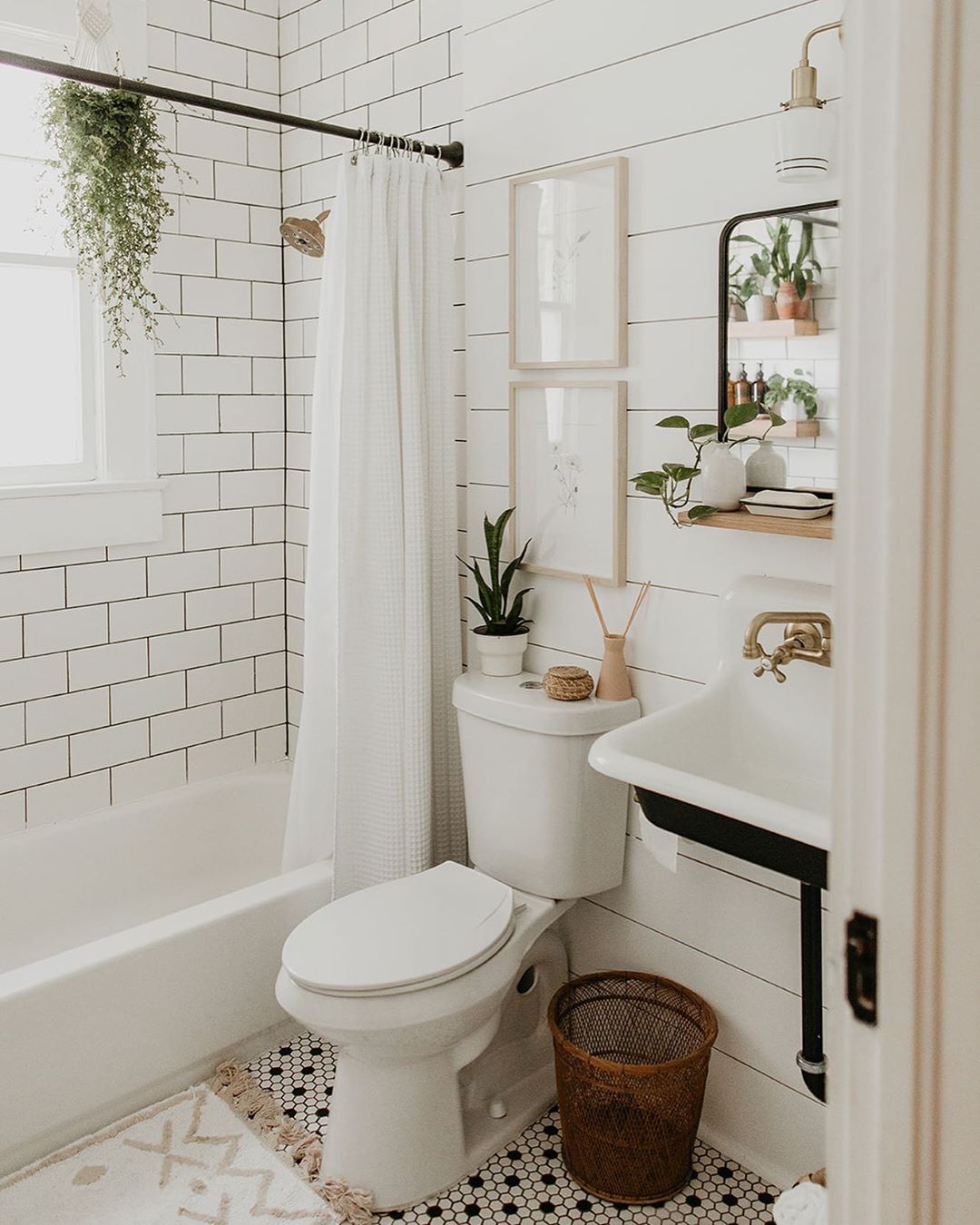 new bathroom with shiplap on the wall and subway tiles in shower and pedestal sink photo by Instagram user @carlanatalia__