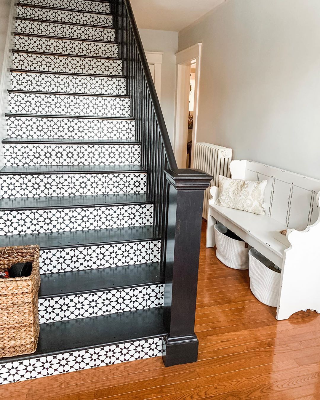 home staircase with black balusters and knule post and wallpaper installed on stairs photo by Instagram user @chasingquinndesign