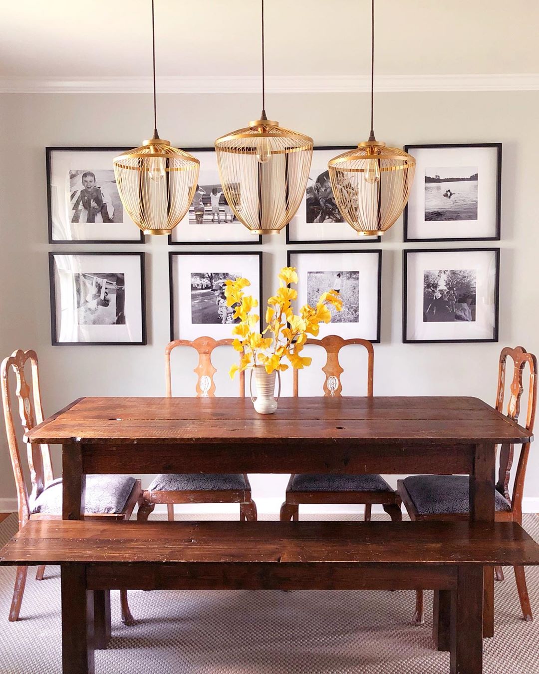 dining room with bench seating and unique lighting with gallery wall photo by Instagram user @thetaborhood