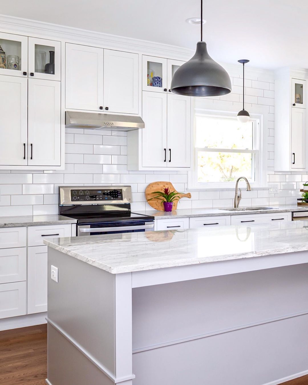 updated kitchen with white cabinets and black hardware photo by Instagram user @clearcutandco