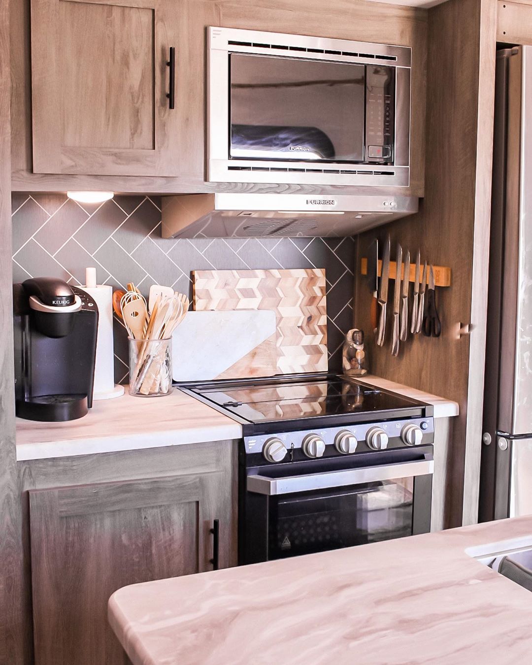 RV kitchen with updated backsplash and faux marble counter photo by Instagram user @laurencicileo