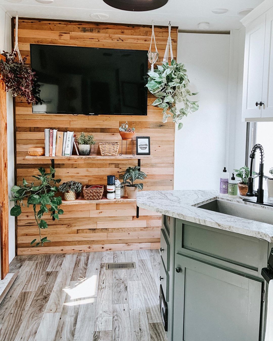 new floating shelves added to RV wall with TV photo by Instagram user @choosing.less