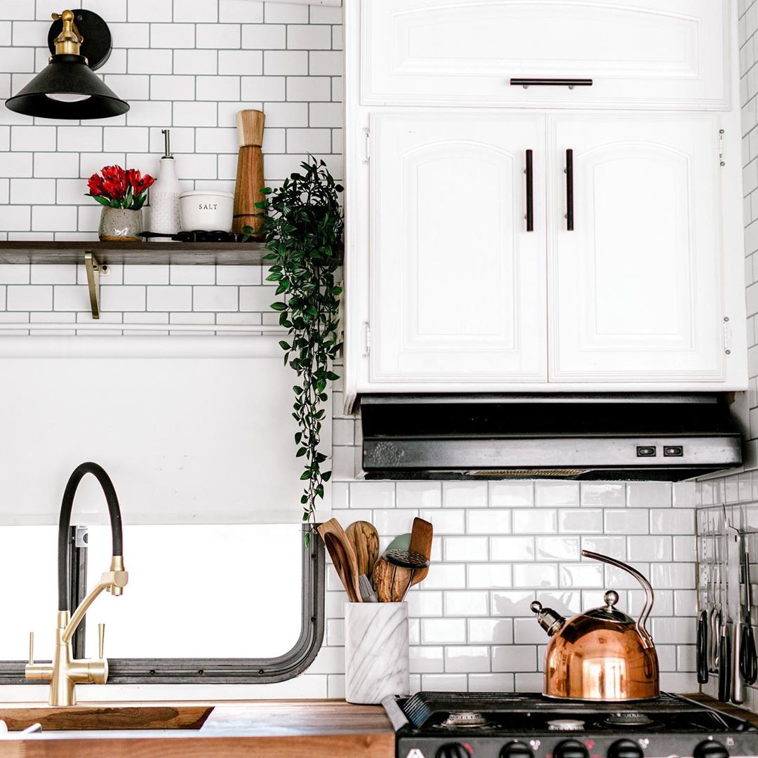updated RV kitchen cabinets with white paint and new hardware photo by Instagram user @haileygolich