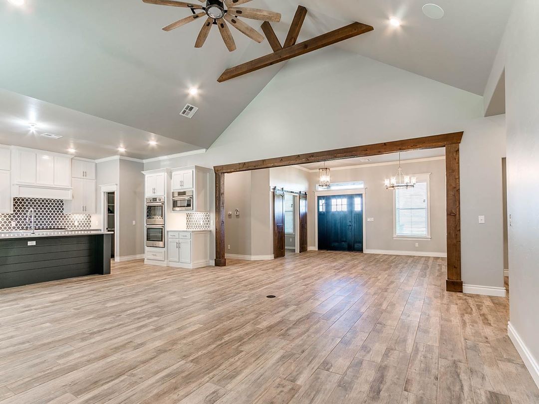 open floor plan in home with all white kitchen and vaulted ceilings photo by Instagram user @griffinhomes