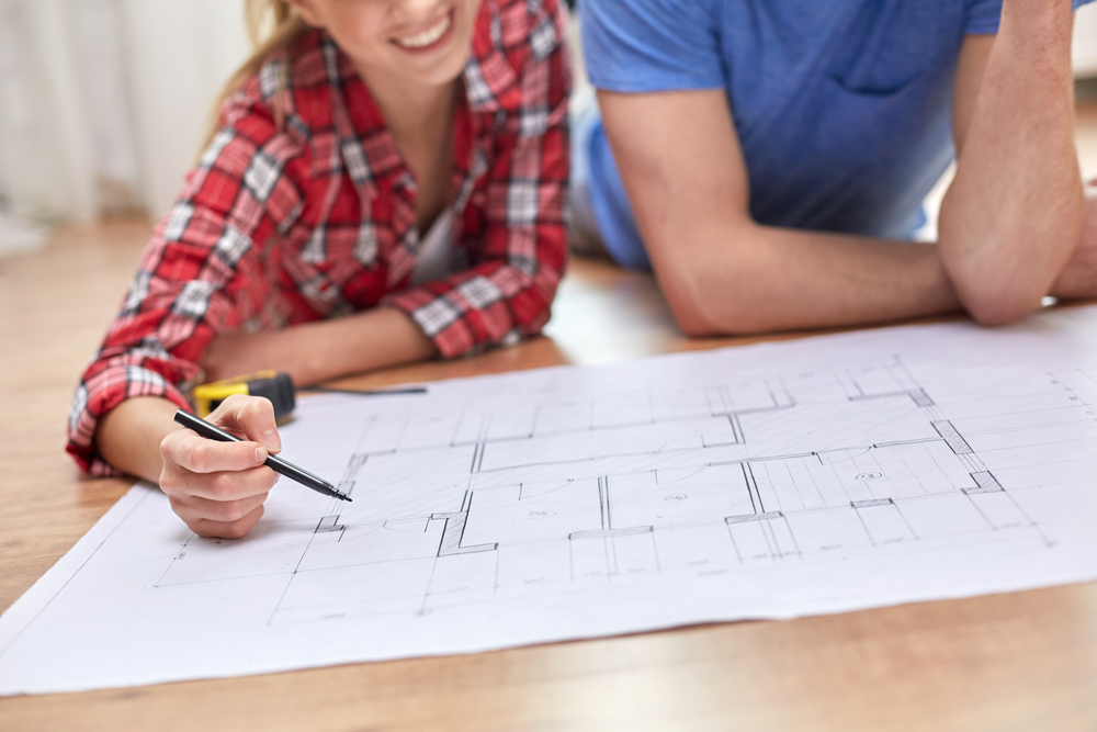 young couple looking a home blueprints