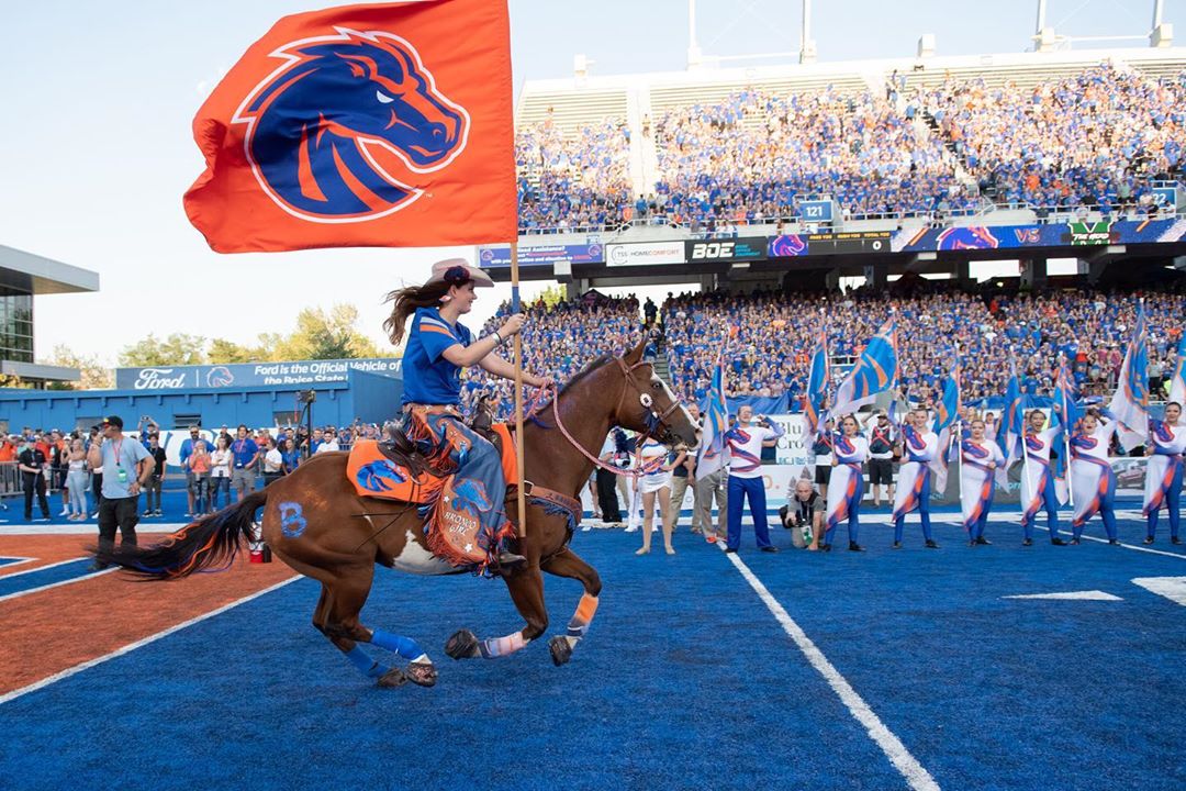 woman riding horse on the blue field at Boise State University photo by Instagram user @boisestateuniversity