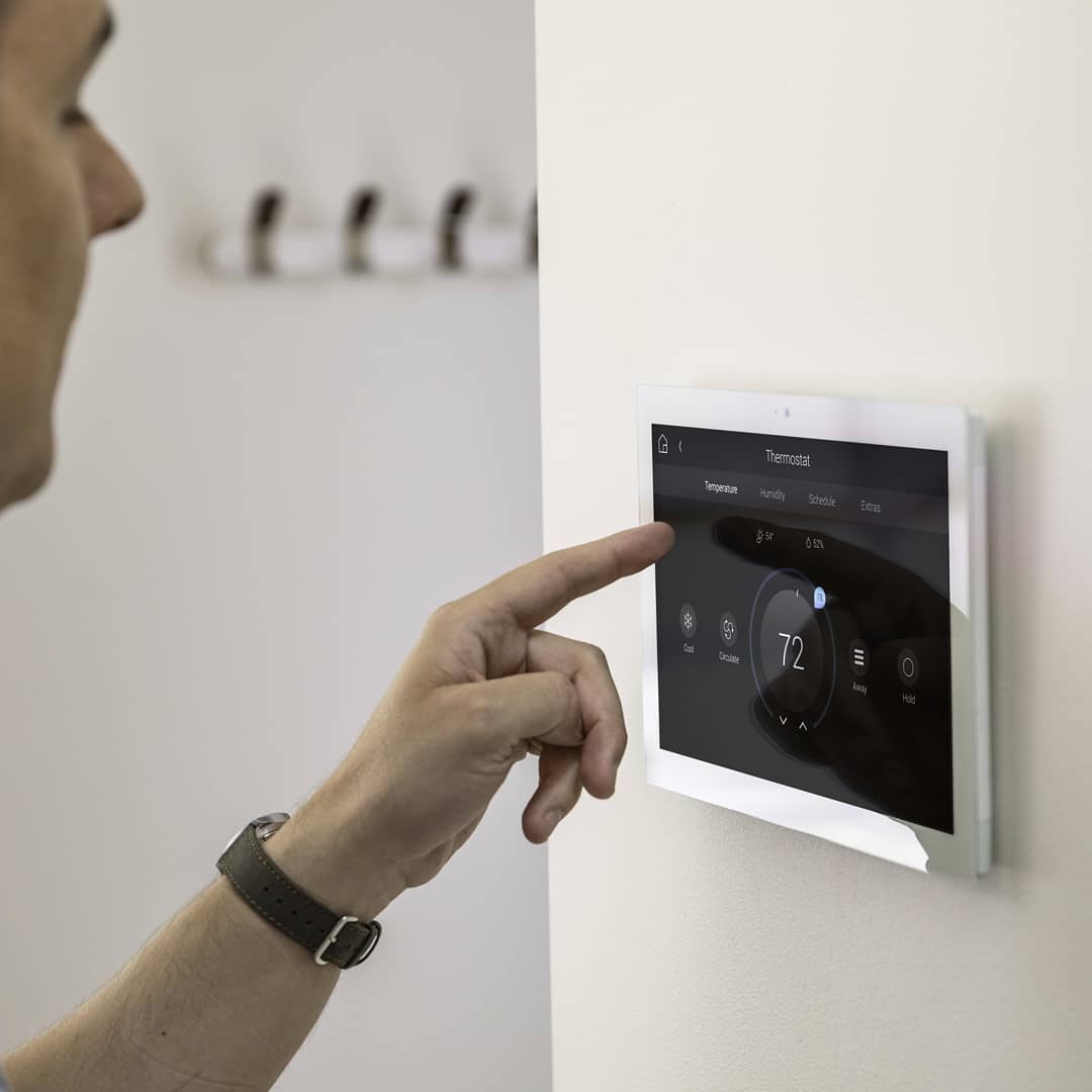man using a smart thermostat in his home photo by Instagram user @haustech__noa