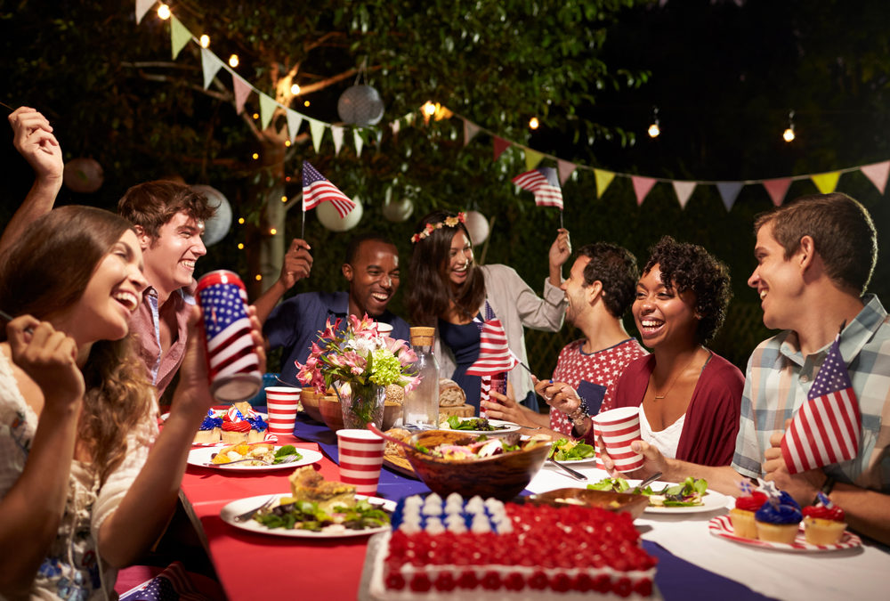 Large Group of People Sitting Around a Table at a Fourth of July Party