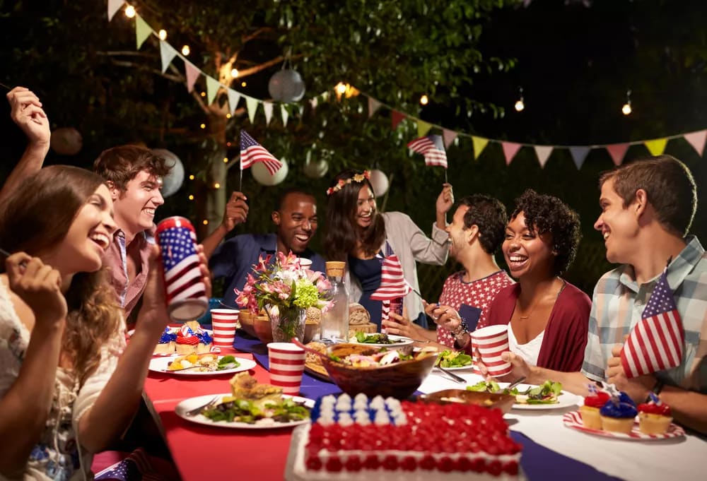 Large Group of People Sitting Around a Table at a Fourth of July Party