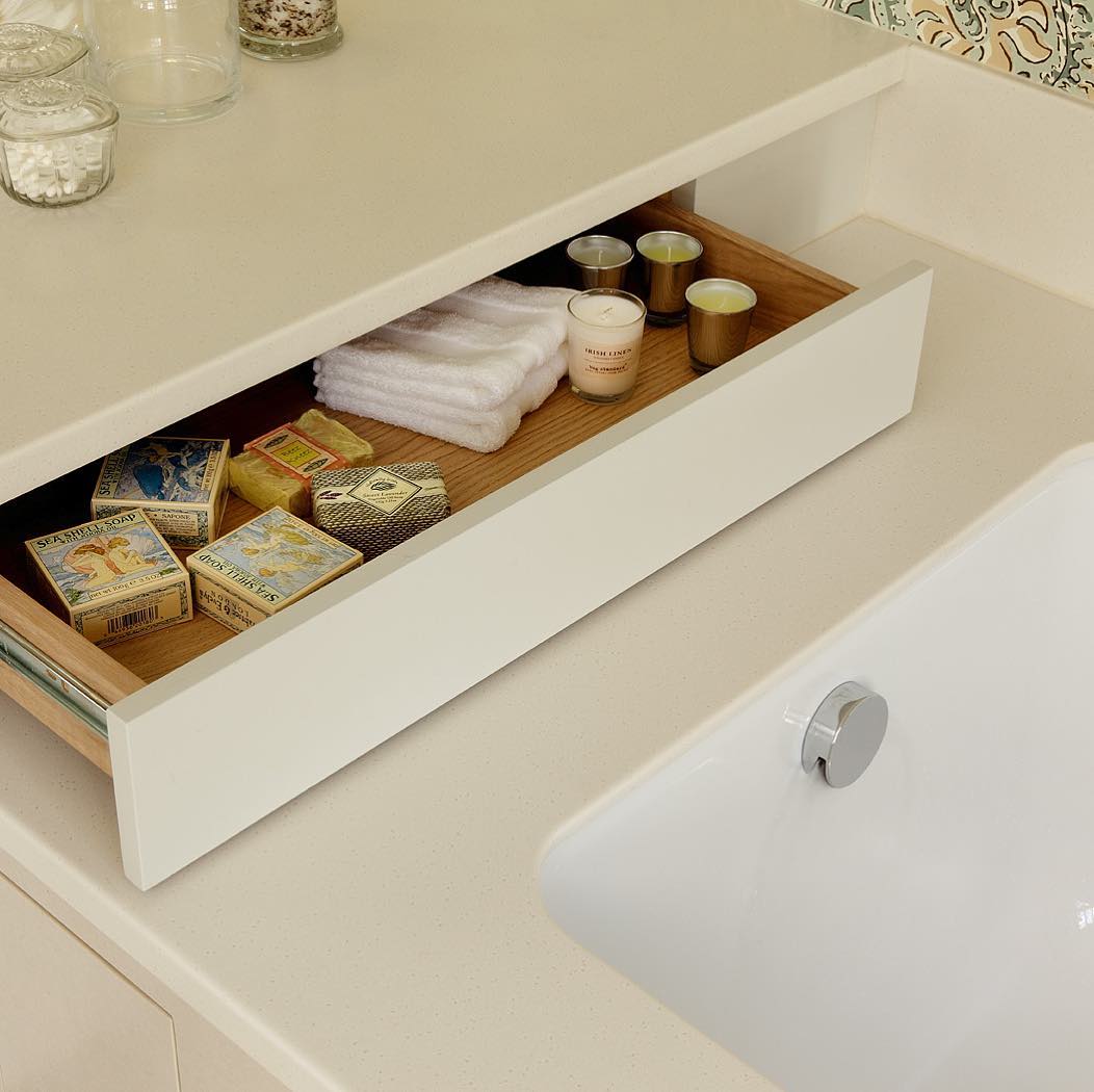 Drawer added underneath an overhanging counter near bathtub. Photo by Instagram user @cueandco