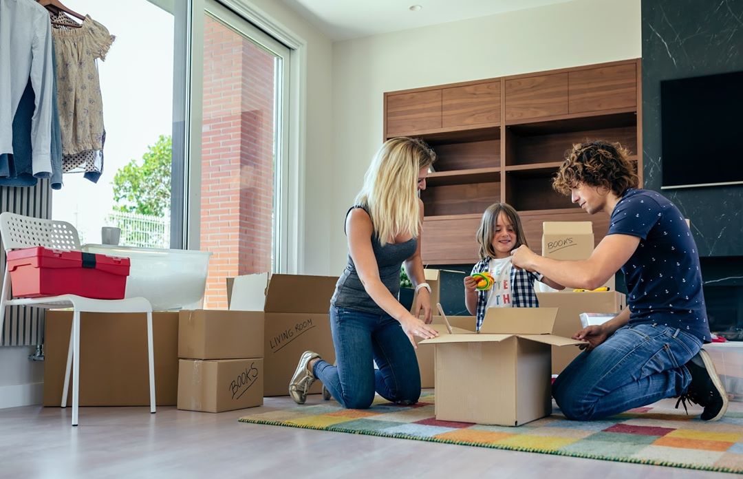 Man, Woman, and Child Kneeling Around a Moving Box. Photo by Instagram user @ipsnycmovers