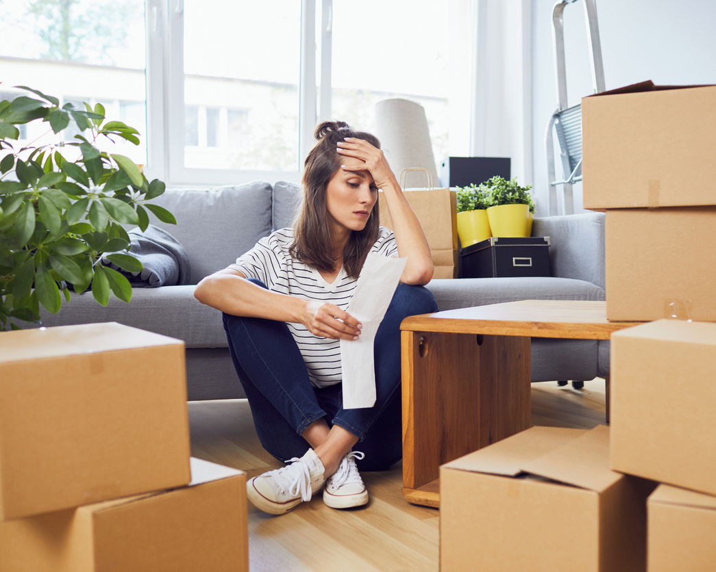 Woman Looking at List While Sitting Amongst Cardboard Boxes. Photo by Instagram user @perezbrothersmoving