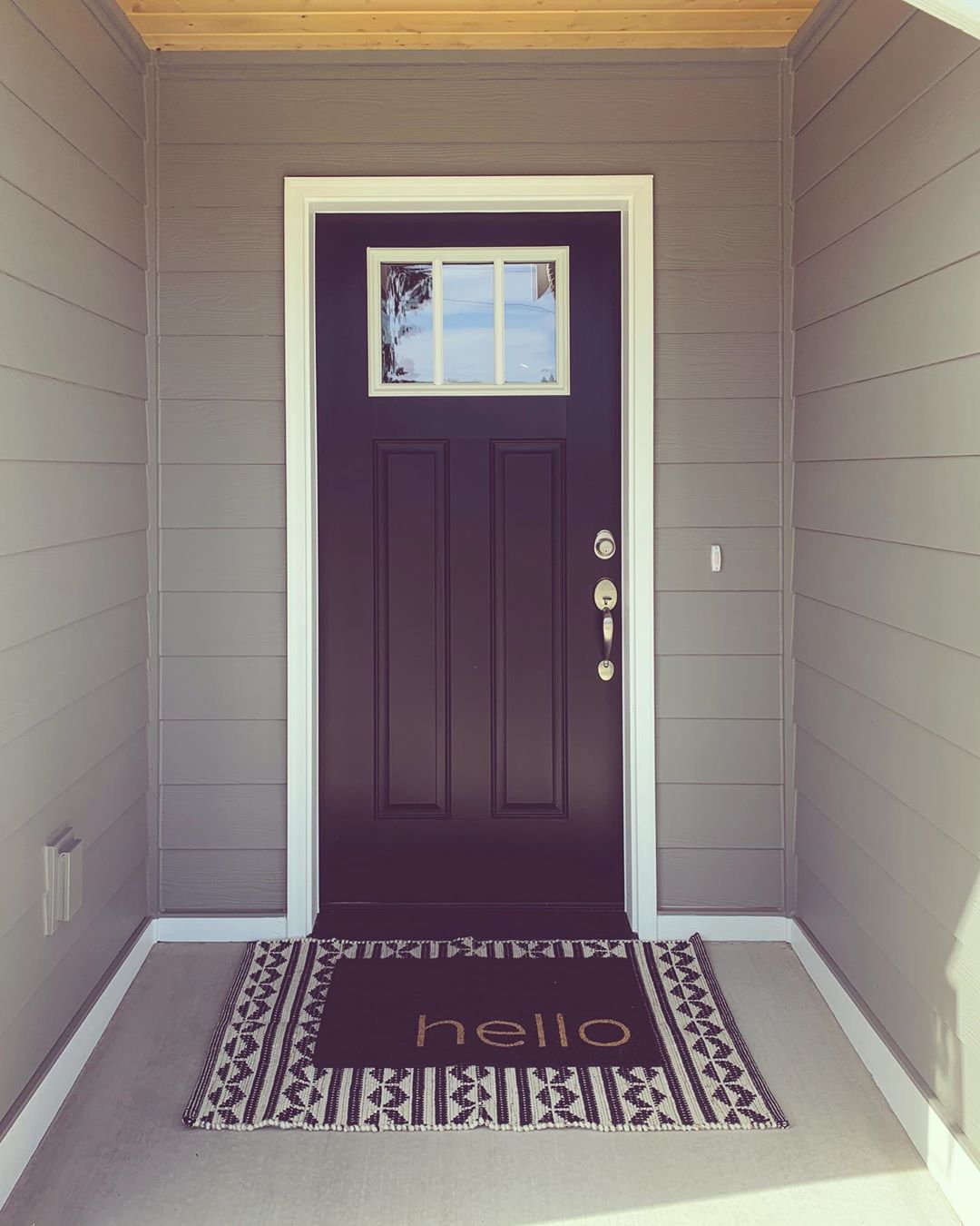 Black Front Door with "Hello" Welcome Mat. Photo by Instagram user @youngmamajohnson