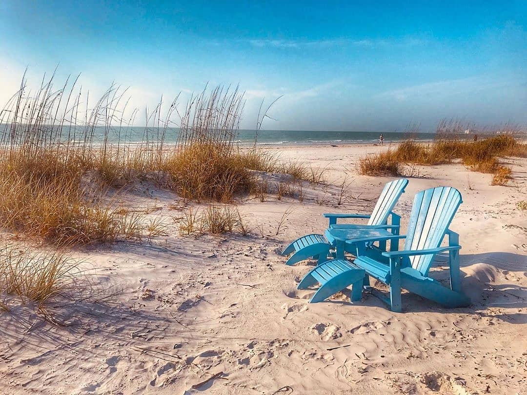 Two Blue Adirondack Chairs on a Beach. Photo by Instagram user @stpetebeach