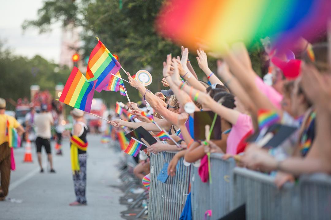 People Along a Parade Barrier Holding Pride Flags. Photo by Instagram user @stpetefl