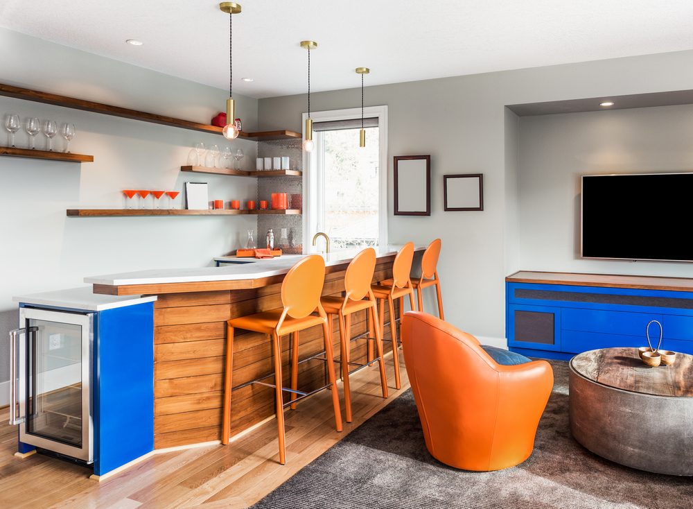 modern bar with wooden barstools and seating in front of a TV