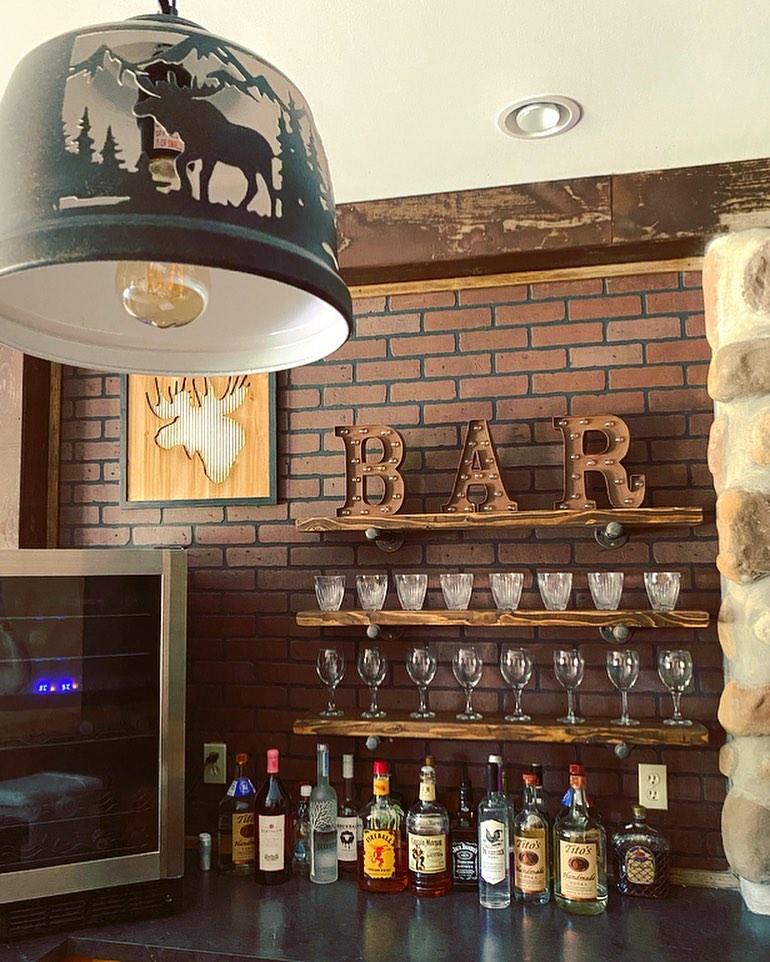 Basement Bar with Faux Bricks and Gas Pipe Shelving. Photo by Instagram user @thelittleblueranch