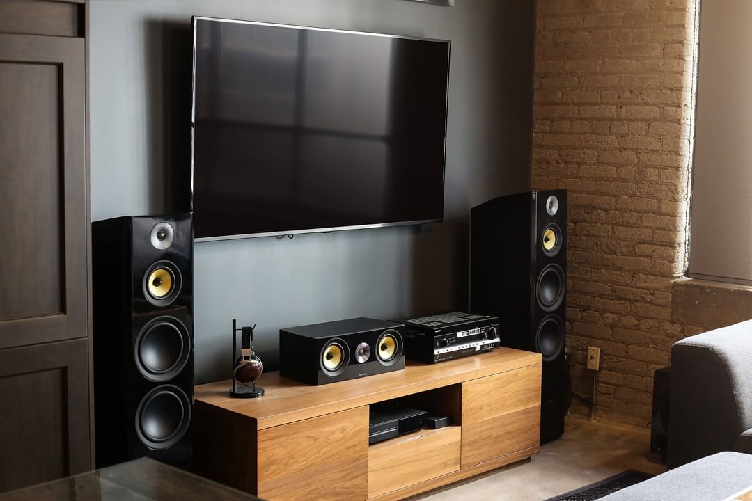 Classic Home Surround Sound Set Up Next to Large TV Hanging on the Wall. Photo by Instagram user @fluanceaudio