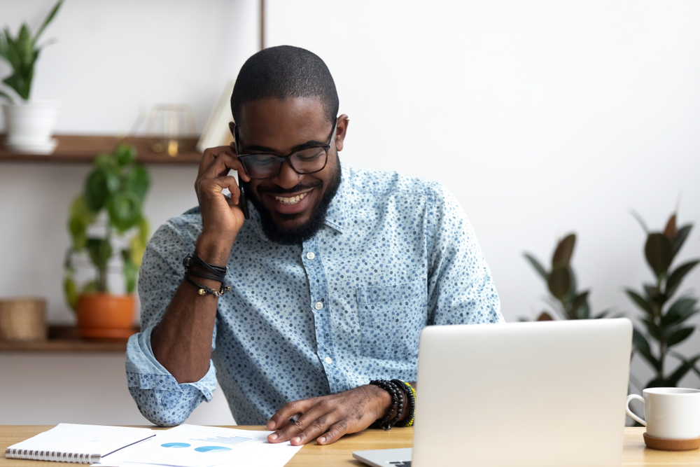 Black man talking on phone about home based business.