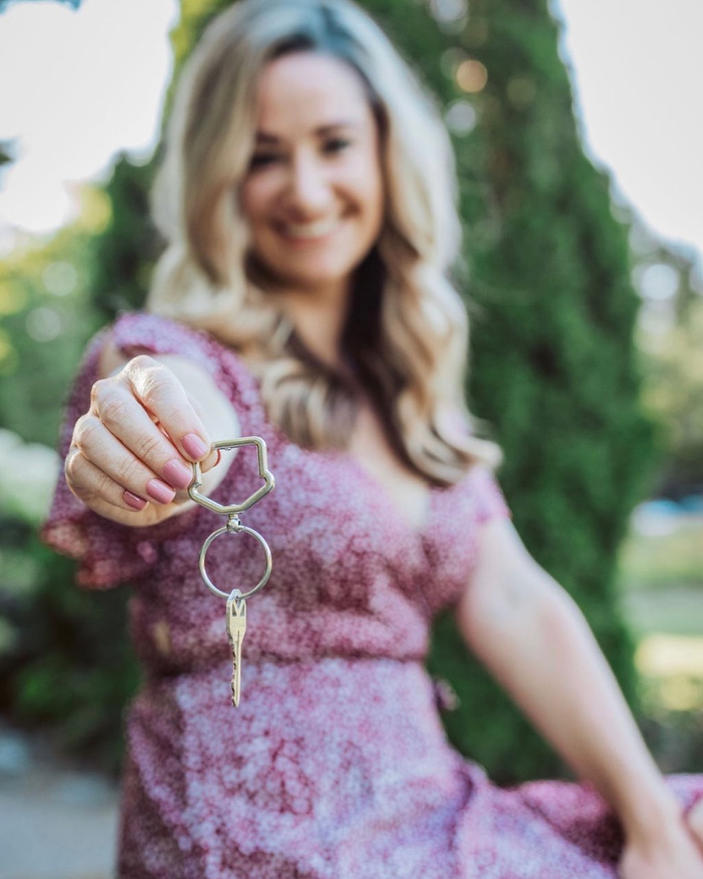 Woman Holding a House Key. Photo by Instagram user @courtmcmahon_realestate