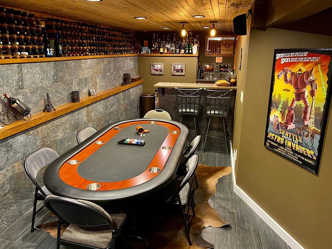 Basement Poker Table Set Up with Wine Racks on the Wall and a Bar. Photo by Instagram user @bubbleandbrown
