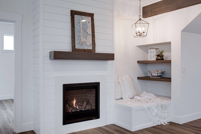 Small Reading Nook Next to a Fireplace with Bright Light Overhead. Photo by Instagram user @northriverhomes