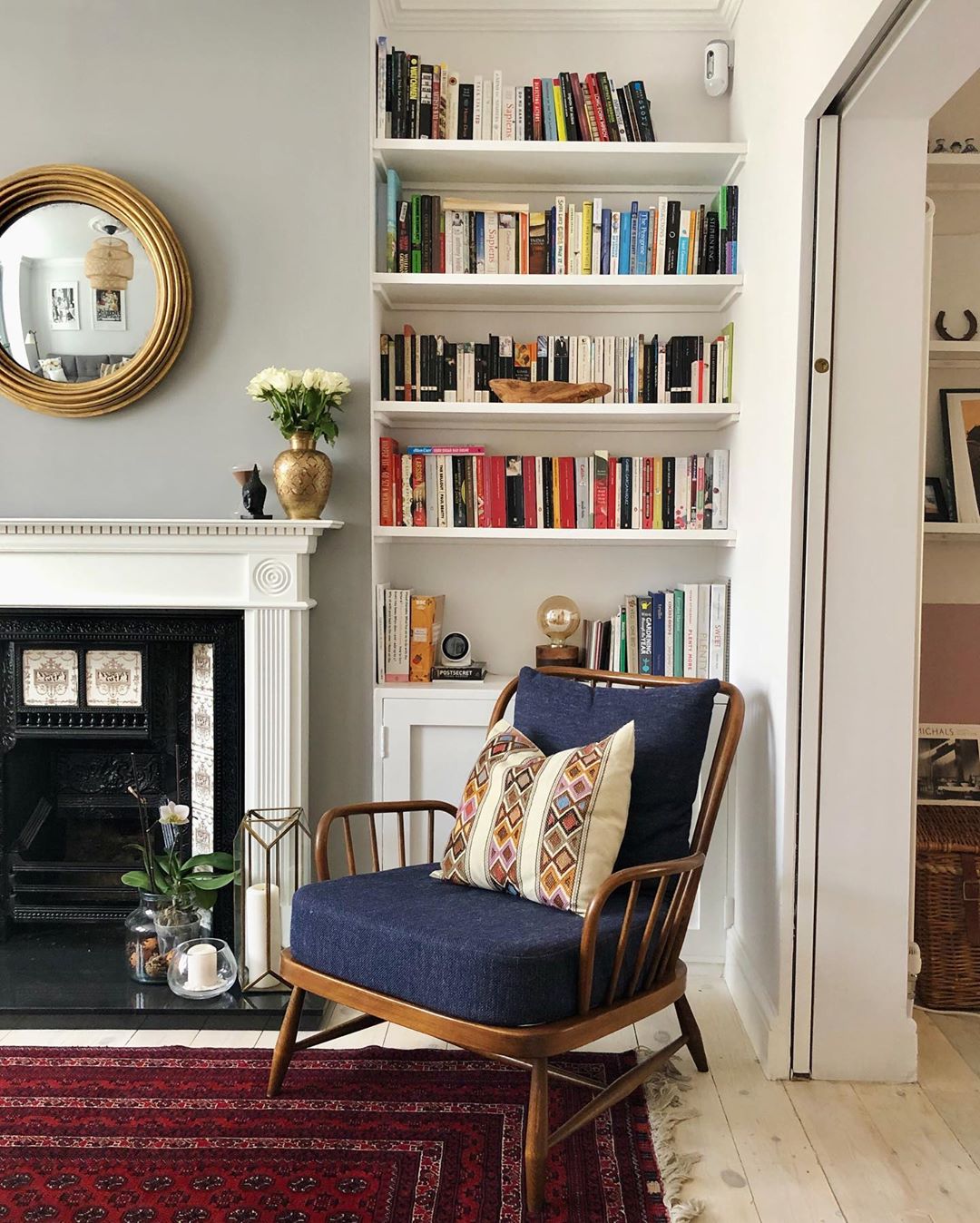 Small Reading Area in a Living Room with Comfy Chair and Bookshelves. Photo by Instagram user @pero_homes