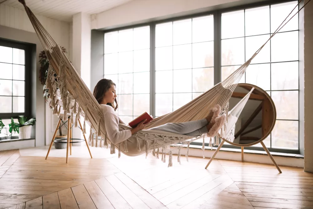 Woman Reading a Book in a Hammock in Her Home