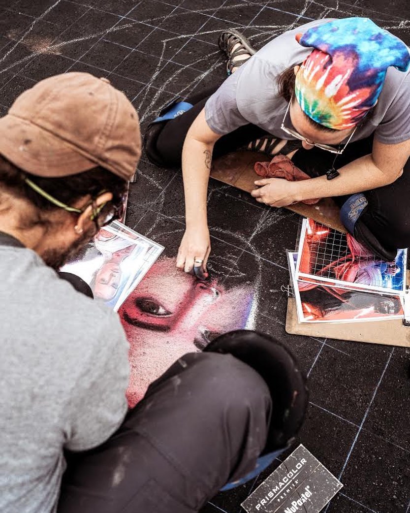 Two People Doing a Chalk Drawing on the Ground. Photo by Instagram user @tempeartfest
