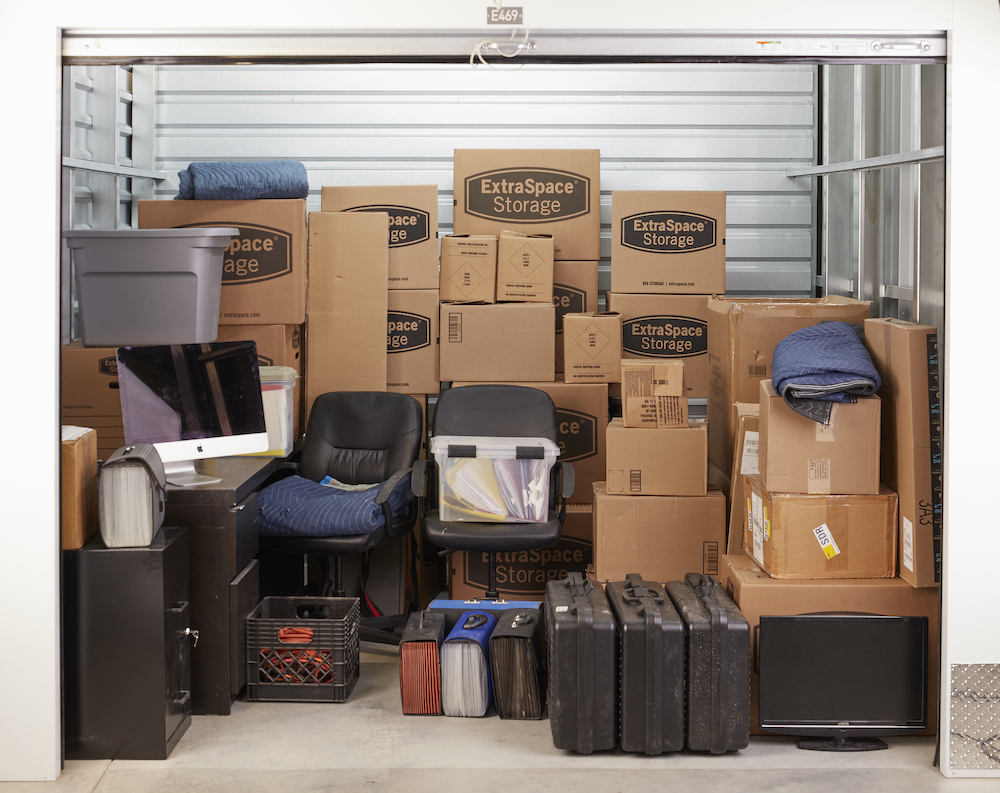 Self Storage Unit Open and Filled with Extra Space Storage Boxes and a Small Desk