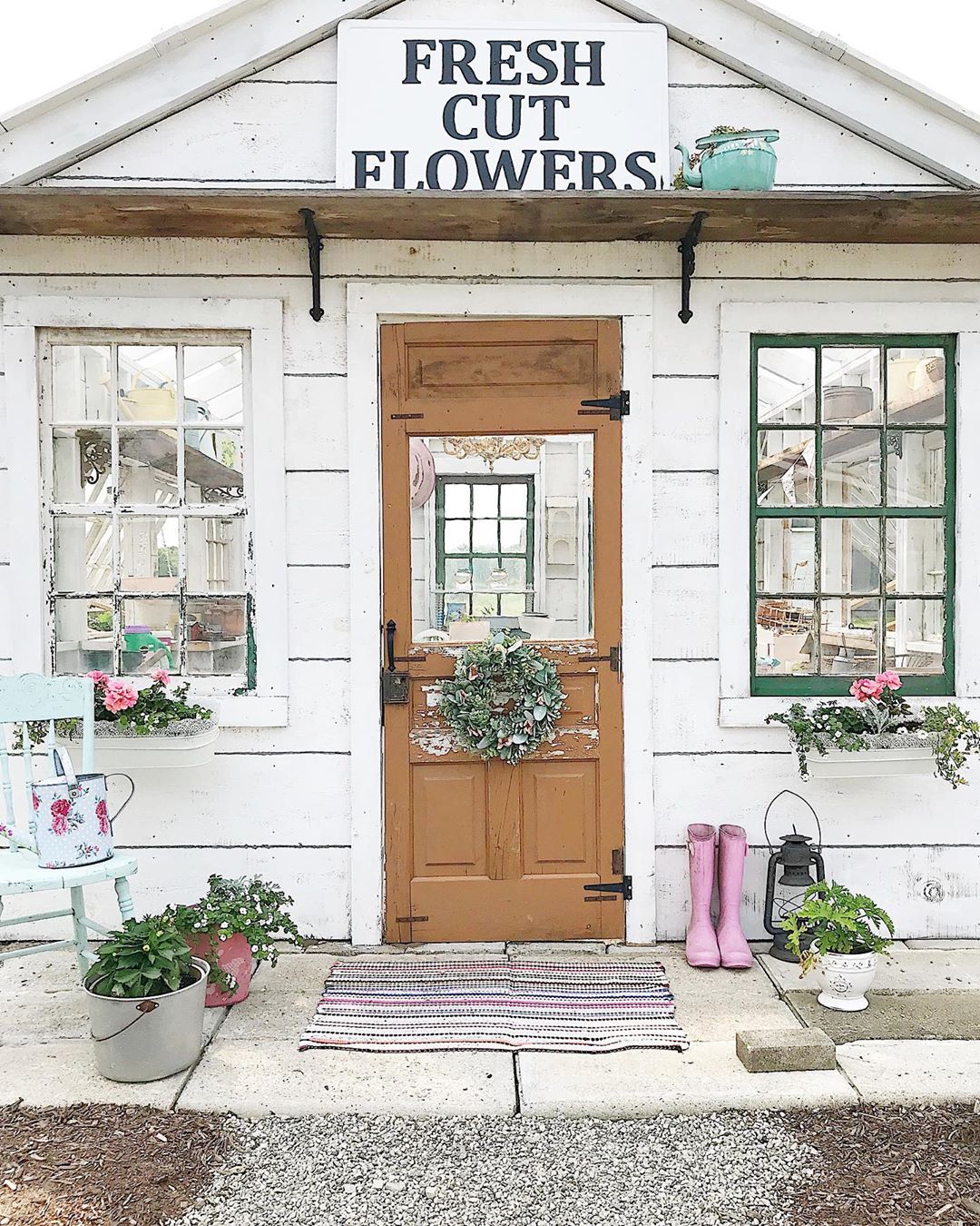 White, Weathered She Shed with Fresh Cut Flowers Sign. Photo by Instagram user @tracey_hiebert