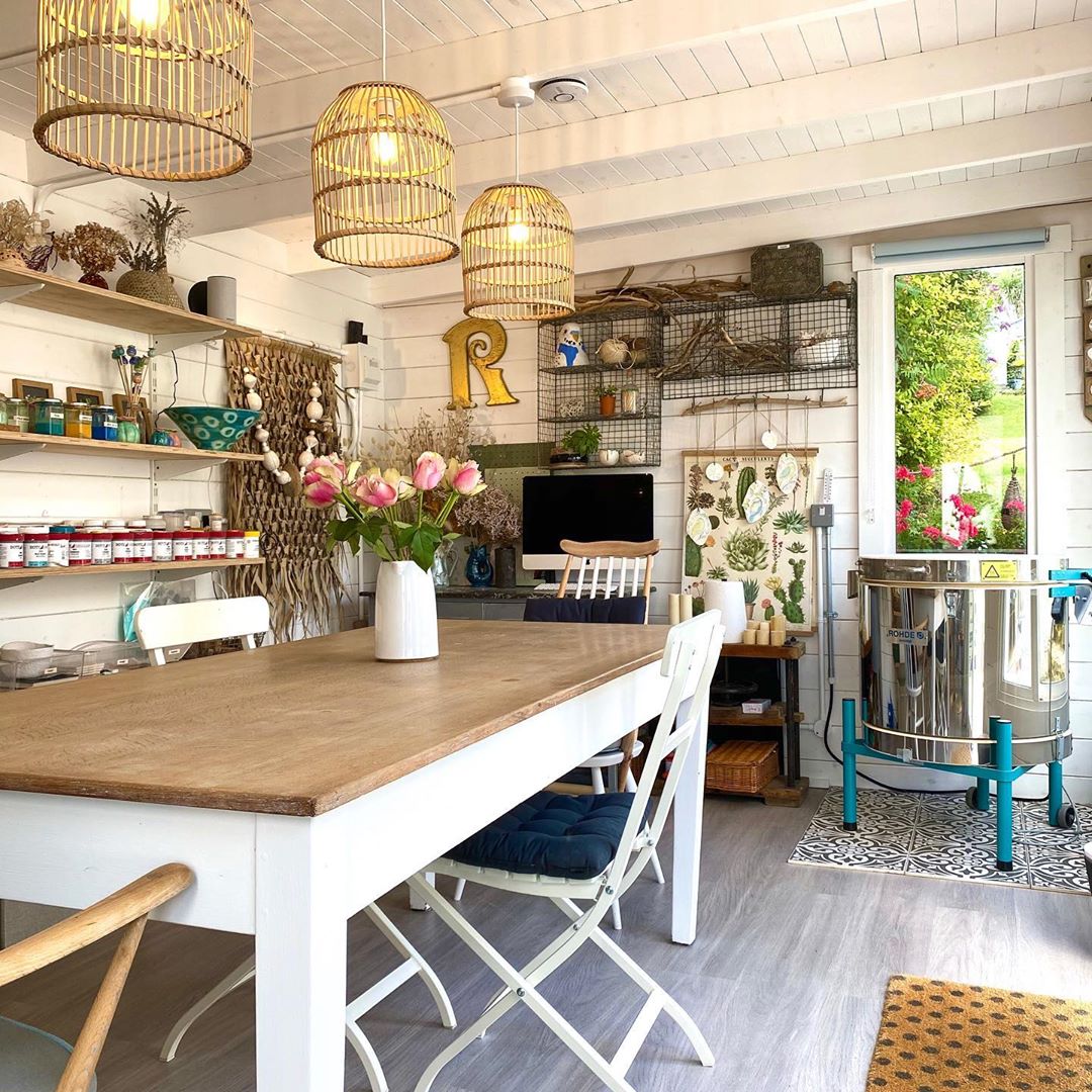 Clean Pottery She Shed with a Large Table in the Middle and a Small Kiln. Photo by Instagram user @rachaeljohnsdesigns