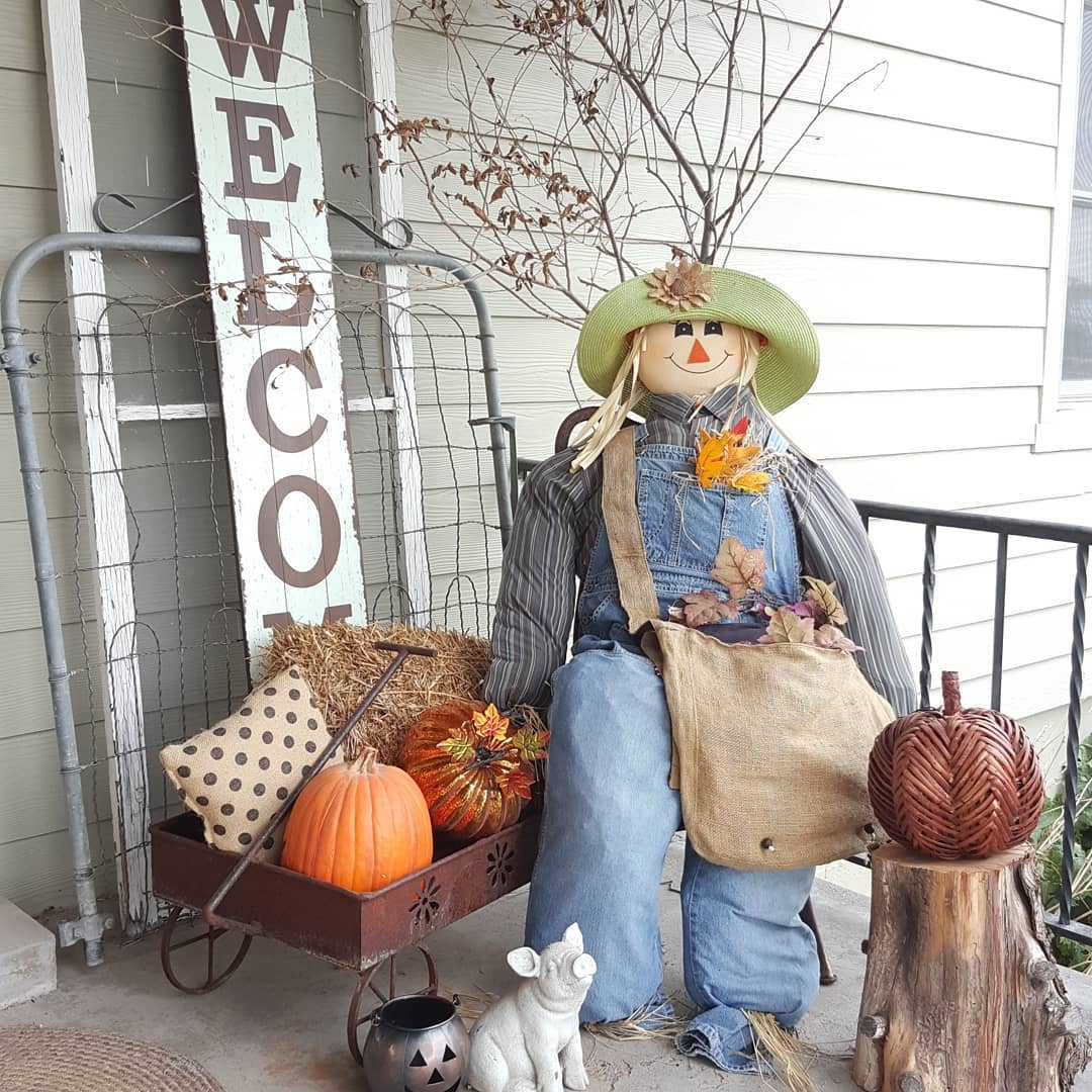 Stuffed Home Made Scarecrow Sitting on a Front Porch. Photo by Instagram user @homedecordoneonabudget