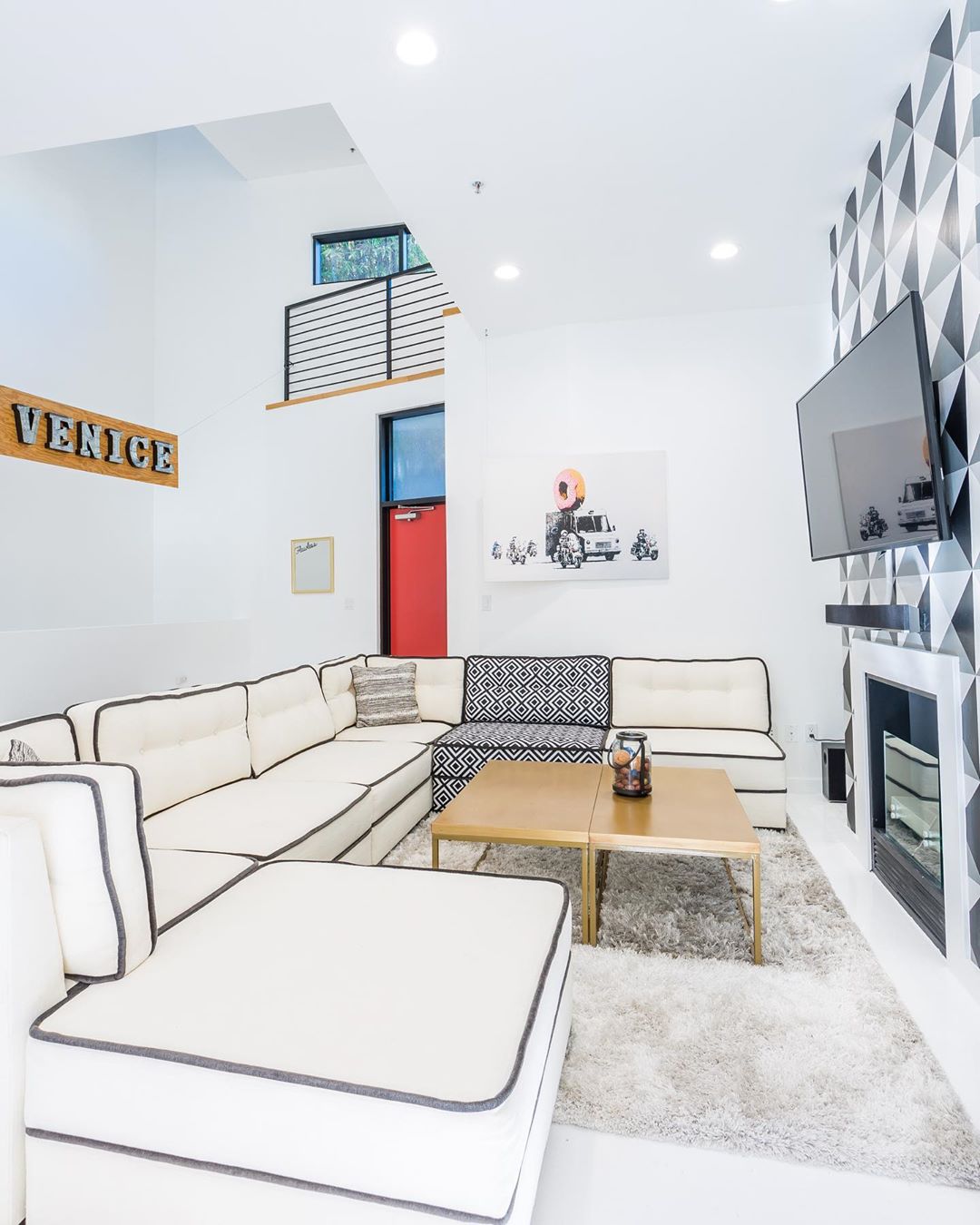 Large Living Space with White Couch and TV on Wall. Photo by Instagram user @bestnestliving