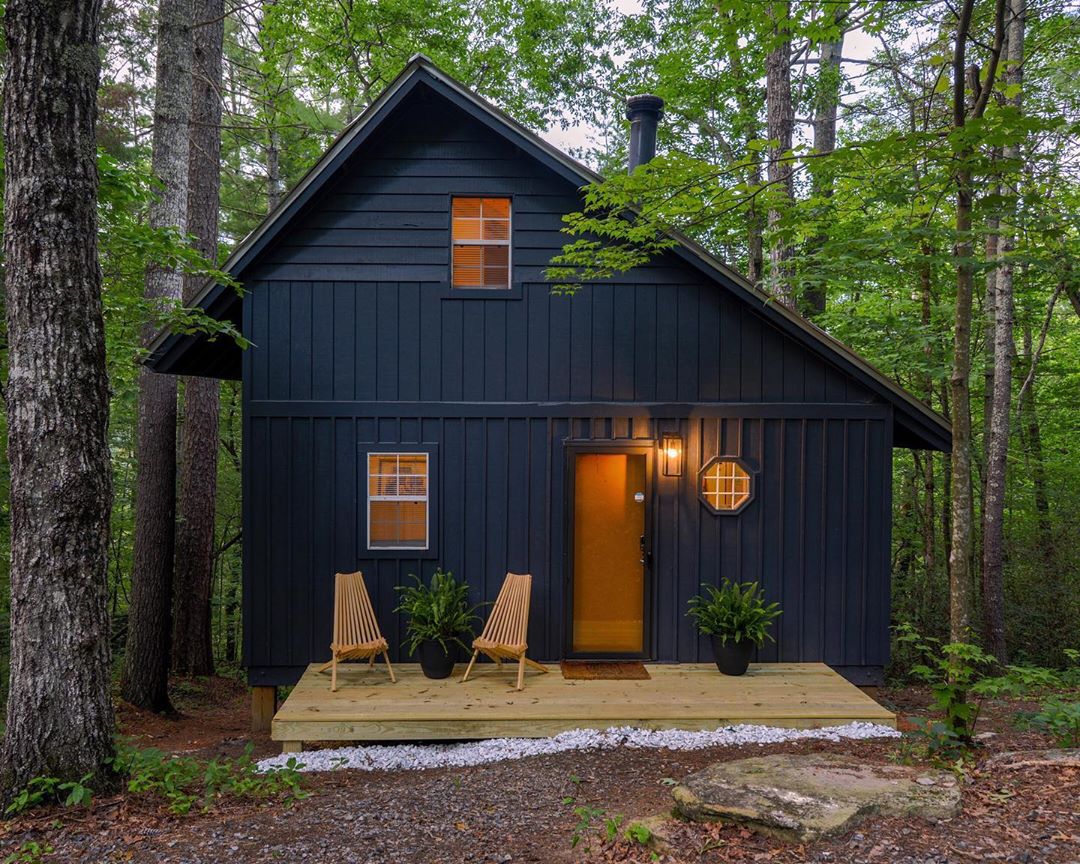 Blue Cabin in the Woods with Small Front Wooden Patio. Photo by Instagram user @tinymountaincabin