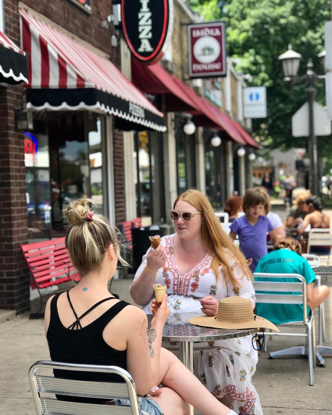 Two Women Sitting Outside of Grand Ole Creamery & Pizza on Grand Ave. Photo by Instagram user @grandolecreameryandpizzeria