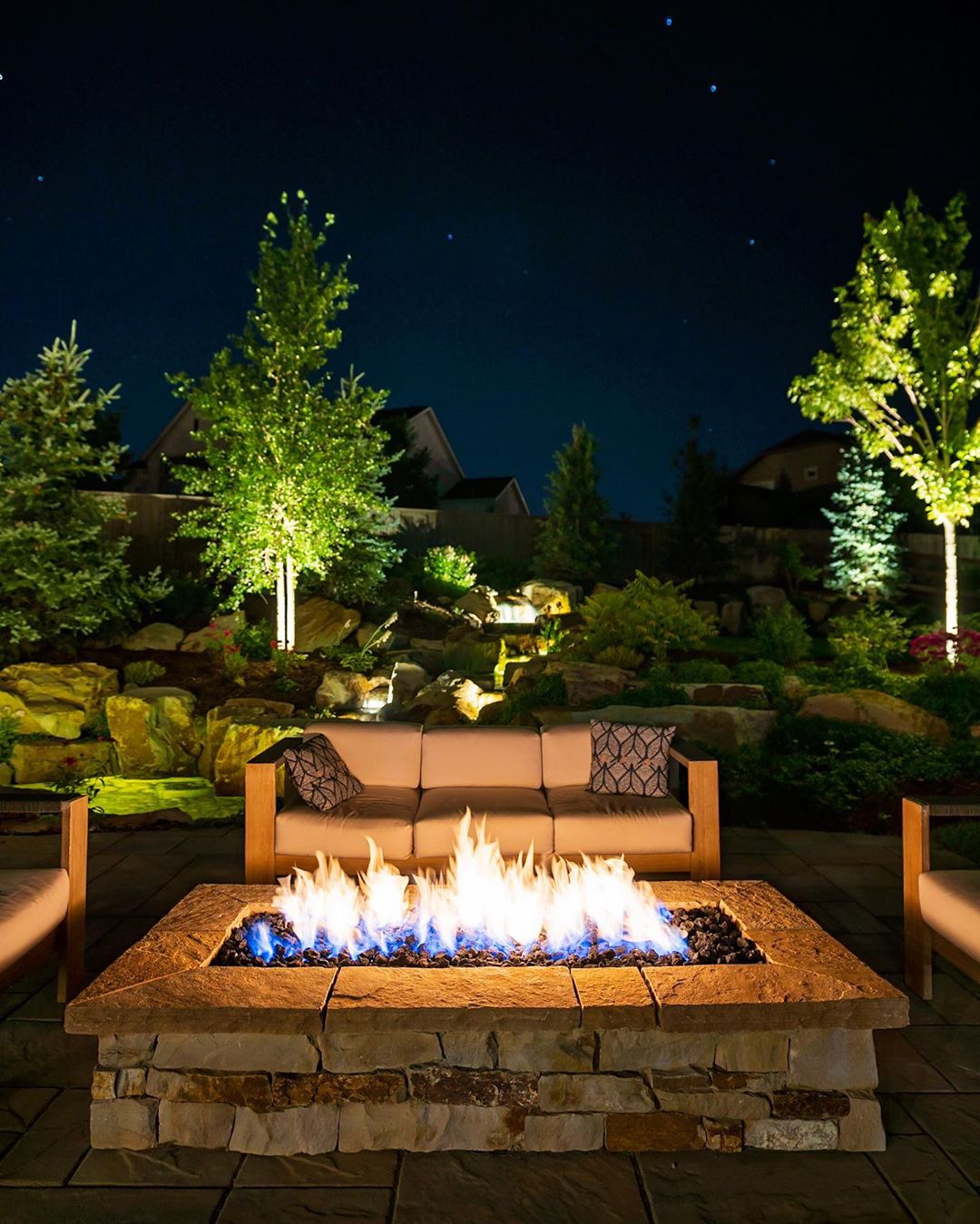 Backyard Fire Pit with Nice Furniture Around and Landscape Lighting. Photo by Instagram user @hineroutdoorliving