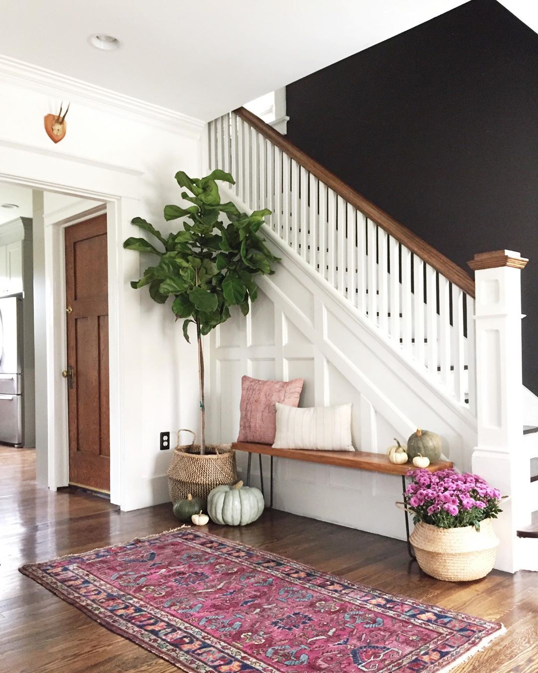 Freshly Painted Foyer with White Trim and Black Accent Wall. Photo by Instagram user @carpendaughter
