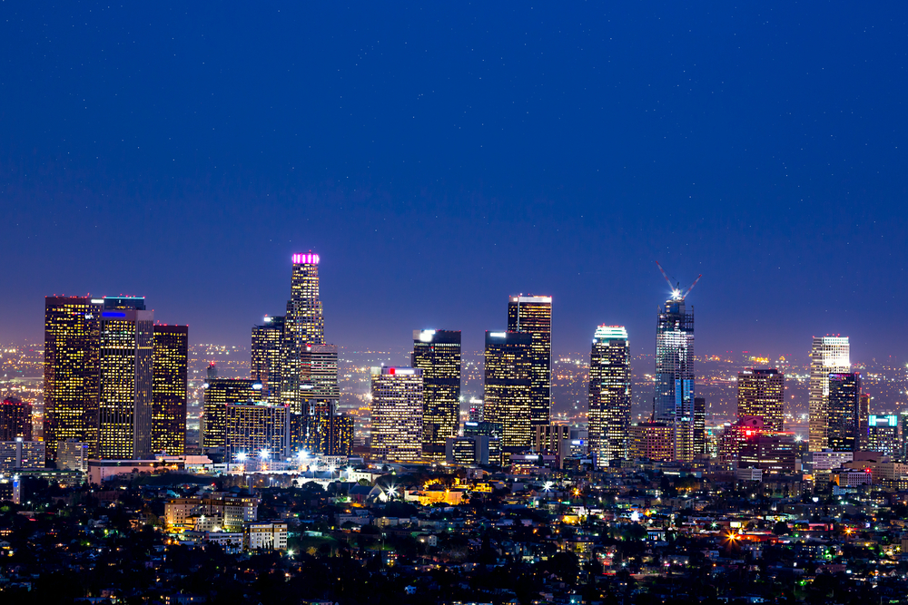 Twinkling lights of Los Angeles skyline and city streets seen from a distance at dusk