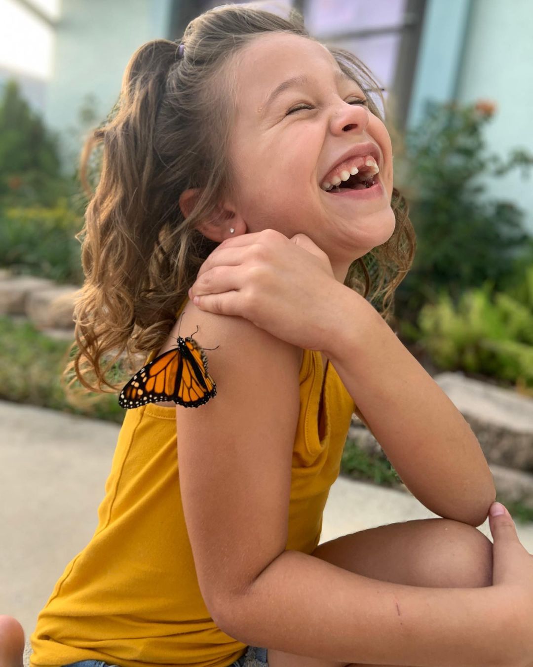 Little Girl Laughing with a Butterfly on her Arm. Photo by Instagram user @butterflyworldflorida