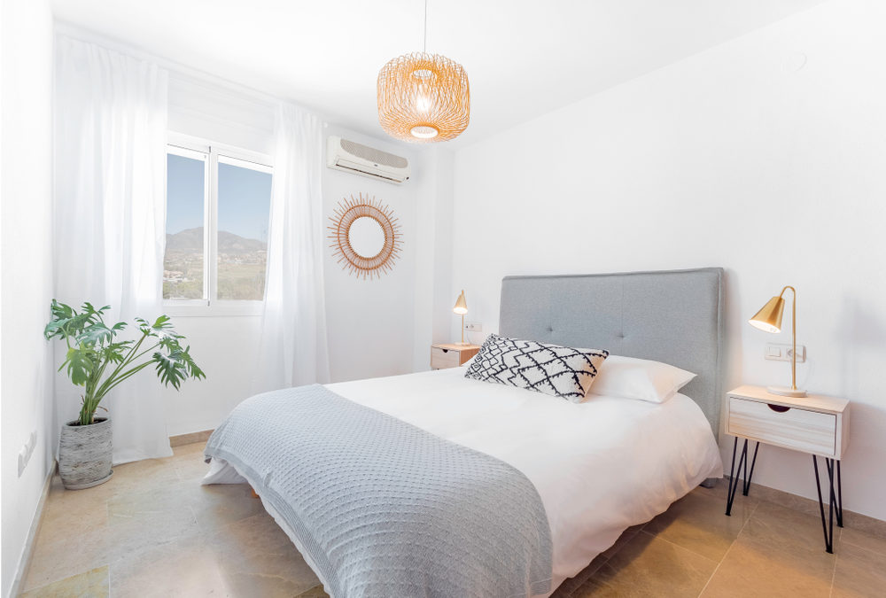 Clean Bedroom with White Walls and White and Blue Bedspread