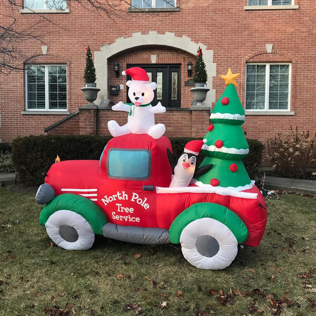 An inflatable red truck holds a penguin and Christmas tree in the bed, and a polar bear cub with a Santa hat on top. Photo by Instagram user @i_love_winnetka.