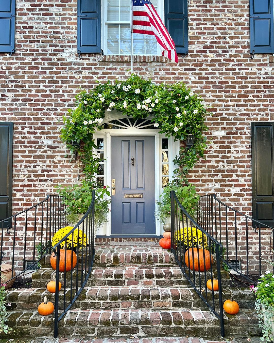 brick house with mum and pumpkins. photo via @thecharlestonlens