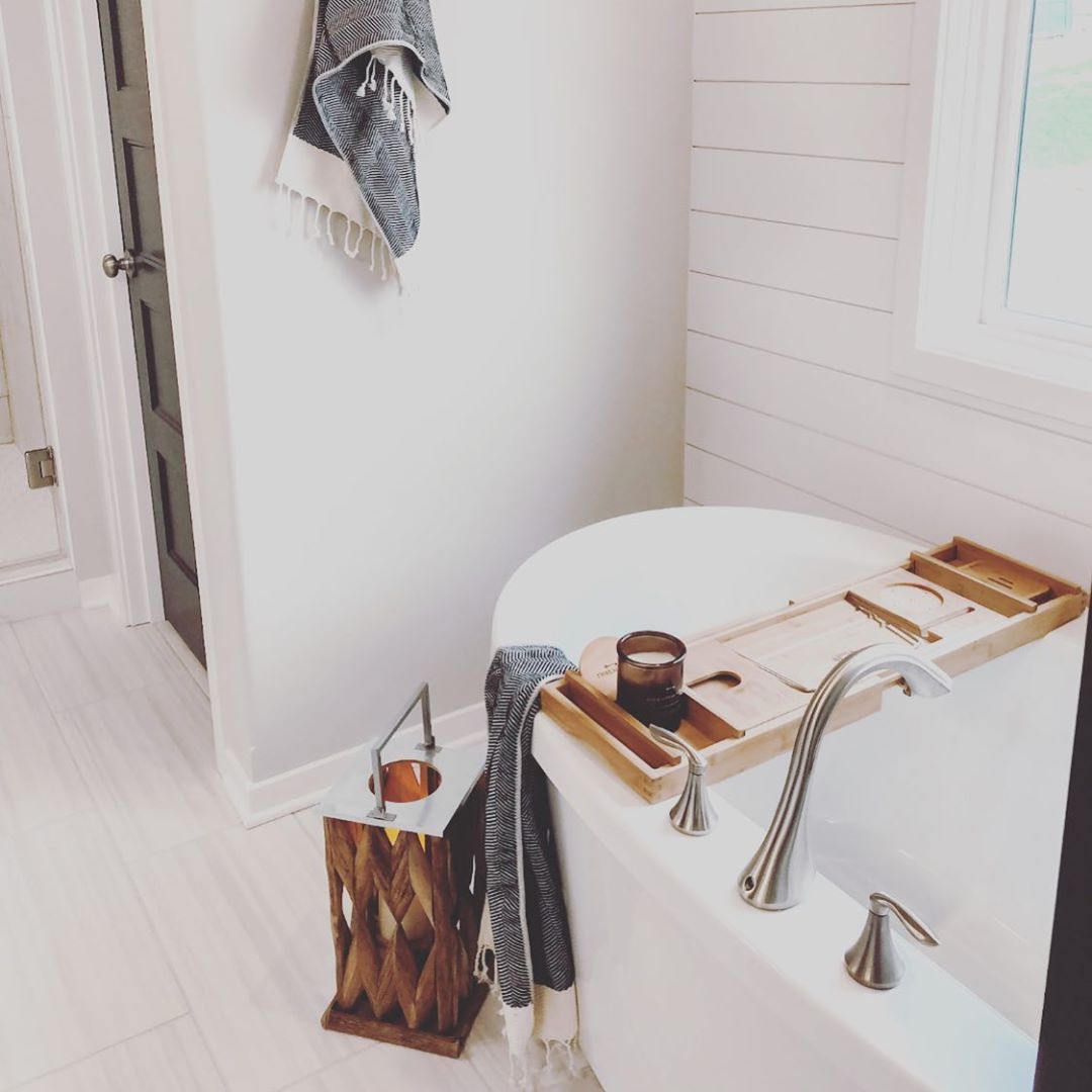 White bathroom with bathtub. Photo by Instagram user @ouralmostlakehouse
